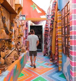 muž kráčející uličkou s barevnou podlahou