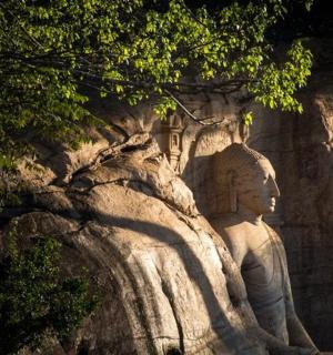 a statue sitting on top of a rocky mountain