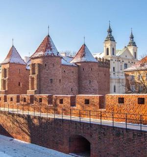 muž kráčející přes most před hradem