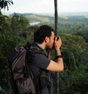 a man with a backpack talking on a cell phone
