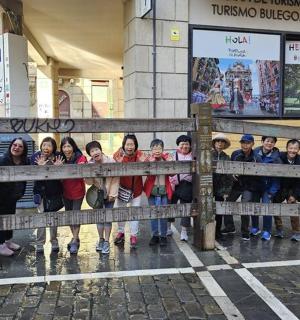 a group of children standing behind a fence