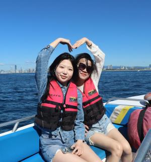 two girls sitting on a boat in the water