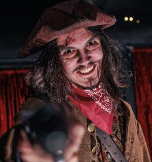 ein als Hexe verkleideter Mann, der mit einer Kamera ein Foto macht