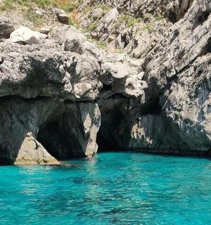 tůň s modrou vodou vedle skalnatého útesu