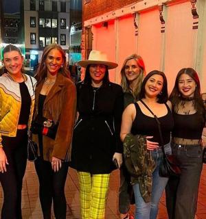 skupina žen pózujících pro fotografii na ulici