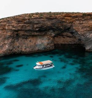 loď ve vodě vedle útesu