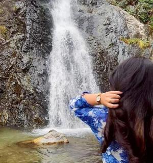 a woman standing in front of a waterfall