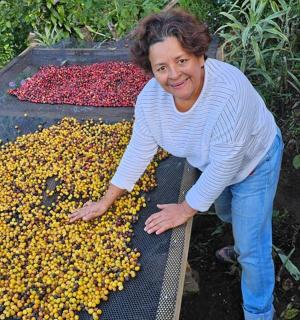 一位女士站在一堆鲜花旁边