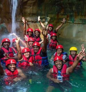 a group of people in a raft in a waterfall