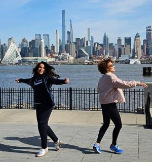 两名女子在城市前的人行道上行走