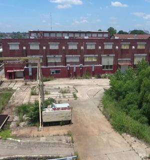 an abandoned building with a train in front of it