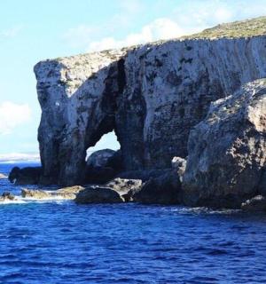 velký skalní útvar ve vodě poblíž oceánu