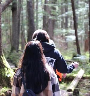 dva lidé jdoucí po stezce v lese