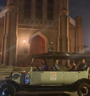 一群人坐在一辆高尔夫球车里,停在一栋建筑前