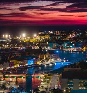 一座夜晚灯火通明、河流环绕的城市