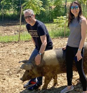 un uomo e una donna in piedi accanto a un maiale