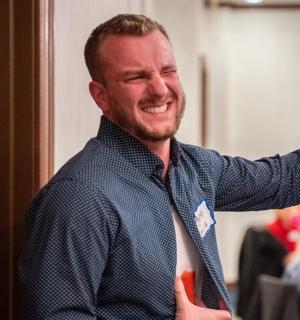 a man wearing a shirt and tie holding a drink