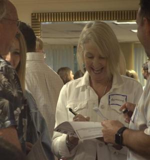 žena se směje, zatímco píše do papíru