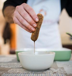 a person pouring a piece of food into a bowl