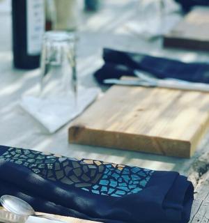 ein Tisch mit blauen Servietten und einem hölzernen Schneidebrett