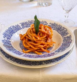 桌上摆着一盘意大利面和银餐具