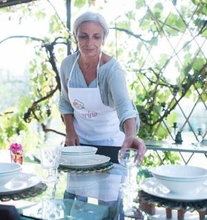 a woman standing in front of a table with dishes