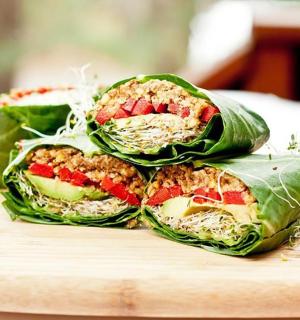 two sandwiches stacked on top of each other on a cutting board