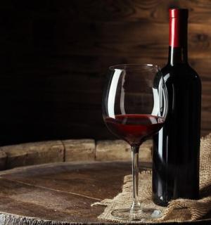 一瓶酒和一杯酒放在桶上