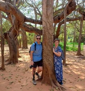 a man and a woman standing next to a tree