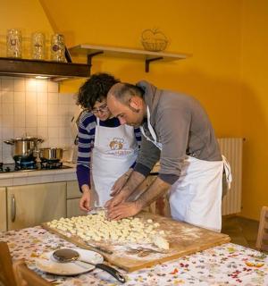 two people in a kitchen preparing food on a table