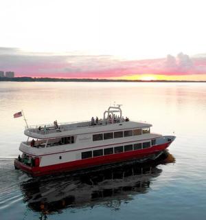 Červenobílá loď ve vodě při západu slunce