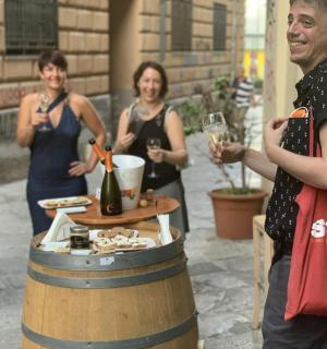 一群人围着酒桶站着，手里拿着酒杯