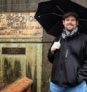 一名男子在标志前打着伞