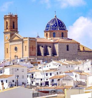 a church on top of a hill with white buildings