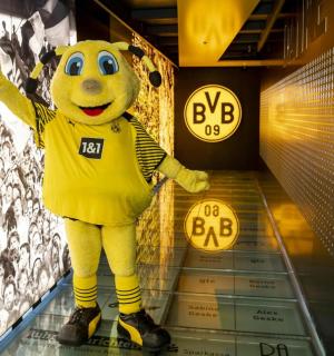 ein gelbes Maskottchen steht in einem Flur