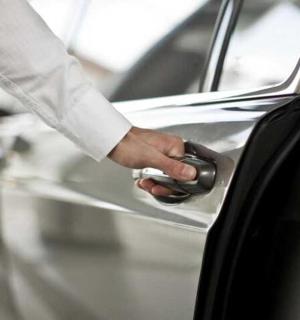 a person opening a car door with a key