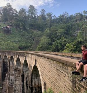 two people sitting on top of a bridge