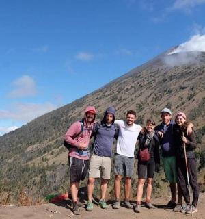 a group of people standing in front of a mountain