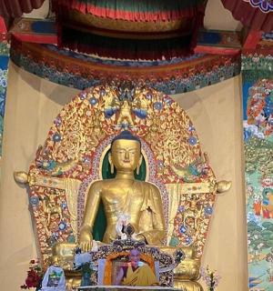 Zlatá socha Buddhy před zdí