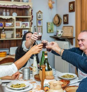 skupina lidí sedících kolem stolu a popíjejících víno