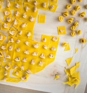 一块木砧板上，放着剥好的香蕉和黄色意大利面