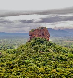 a rock formation on top of a green hill
