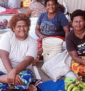 一群人坐在地上,手里拿着香蕉