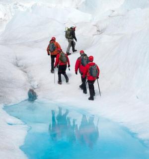 一群人沿着白雪覆盖的河流行走