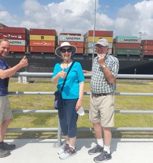 三个人站在船前的栅栏前