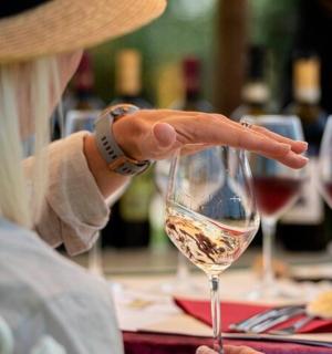 一位女士正伸手去拿一杯酒