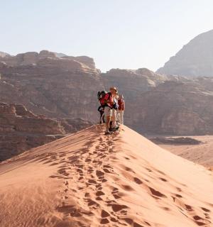 两个人在沙漠沙丘上行走