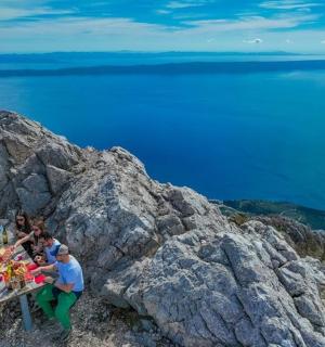 一群人坐在山顶的一张桌子旁