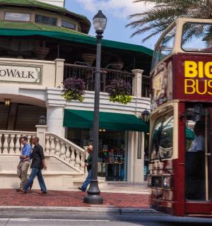 a double decker bus driving down a street with people walking