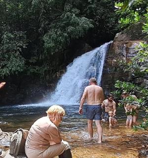 skupina lidí stojících ve vodě poblíž vodopádu